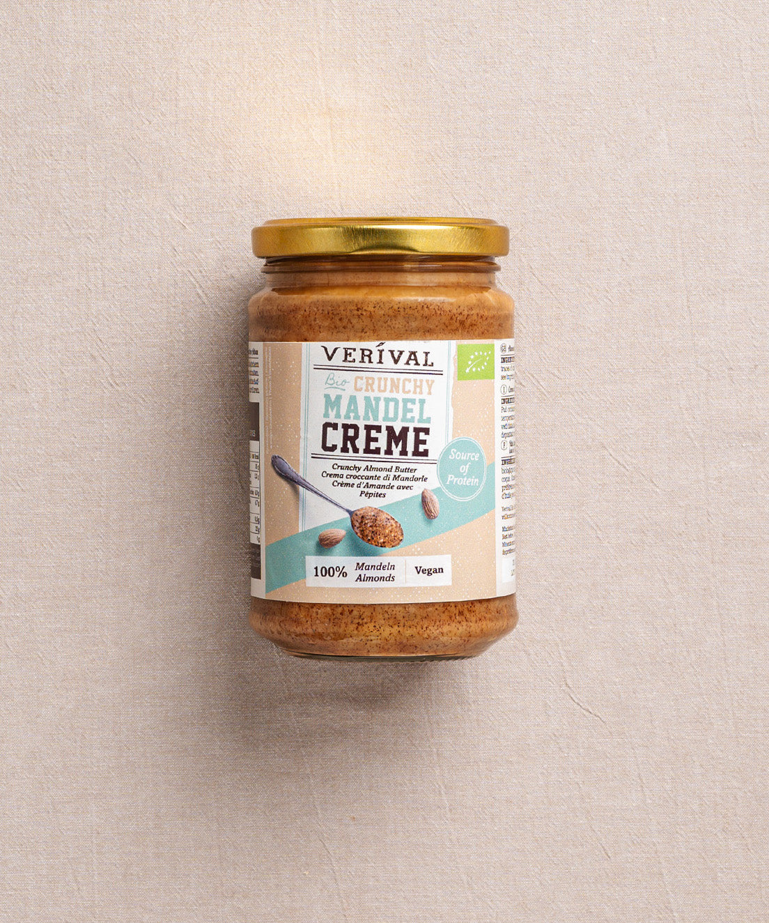 Im „Protein Breakfast“-Set von Verival Bio enthalten ist unter anderem ein Glas Crunchy Mandel Creme mit goldenem Deckel. Das Etikett informiert über die vegane Qualität und 100% Mandelbutter als reichhaltige pflanzliche Proteinquelle.