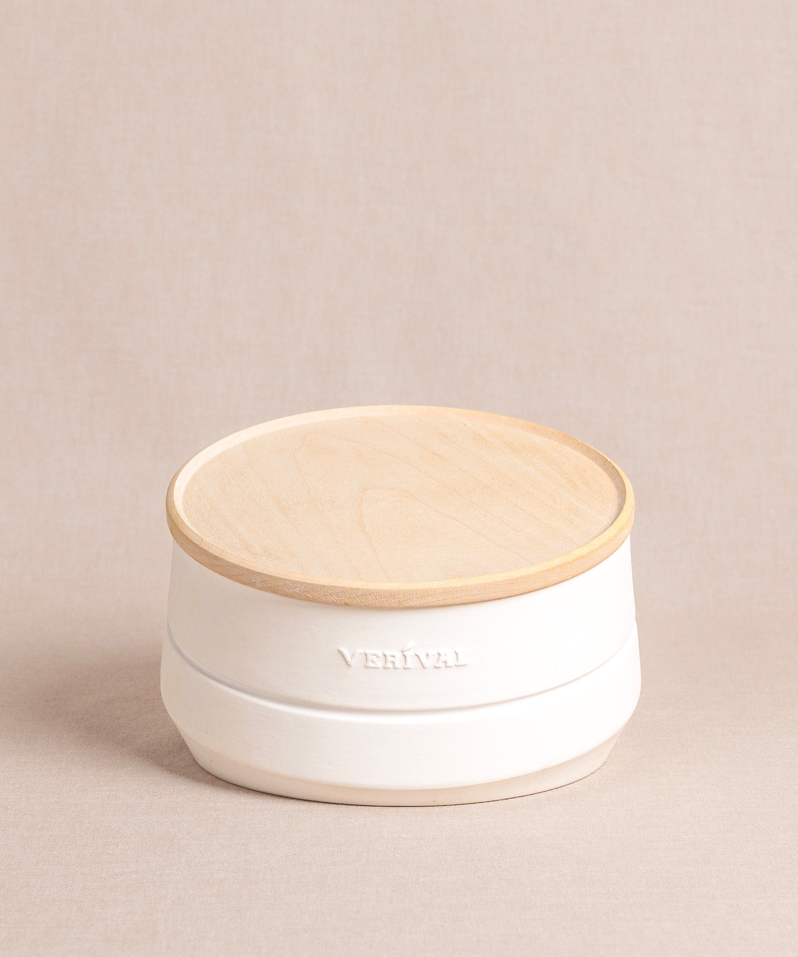 Ein runder, weißer Porzellanbehälter von Verival Bio mit Ahornholzdeckel und der Prägung „VERIVAL“ zur Aufbewahrung von Porridge, Granola, Müsli & Co. 